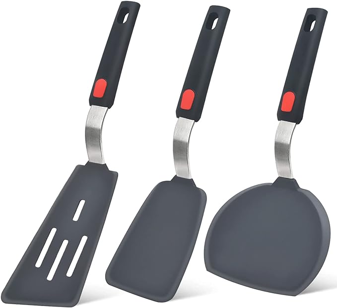 Set of three non-stick spatulas featuring ergonomic black handles with red accents, including a slotted spatula, a solid spatula, and a rounded edge spatula, ideal for flipping and serving food with ease